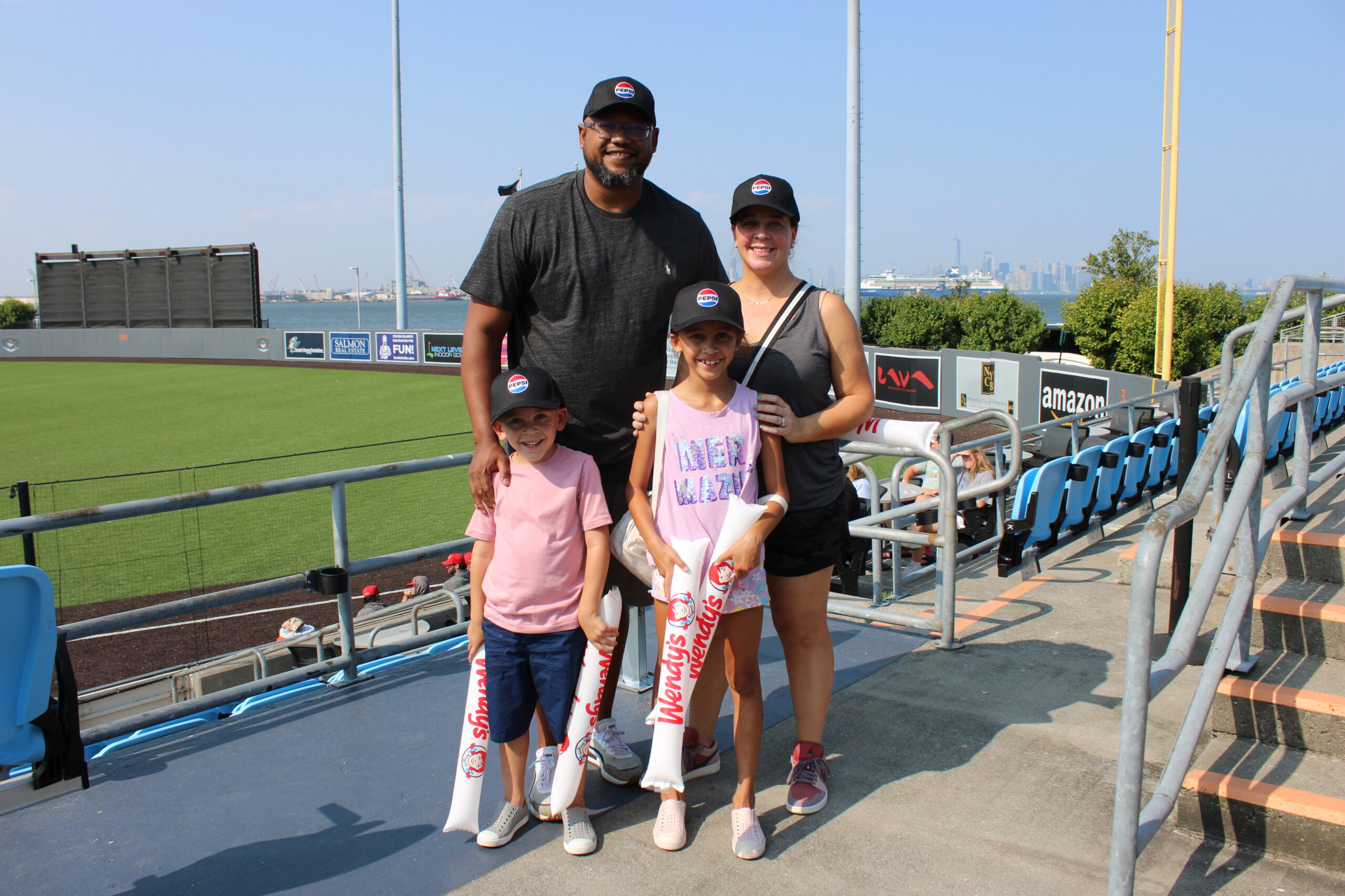 Parents with two kids at a Staten Island FerryHawks Game, part of Honickman's Pepsi NY employee appreciation efforts. 